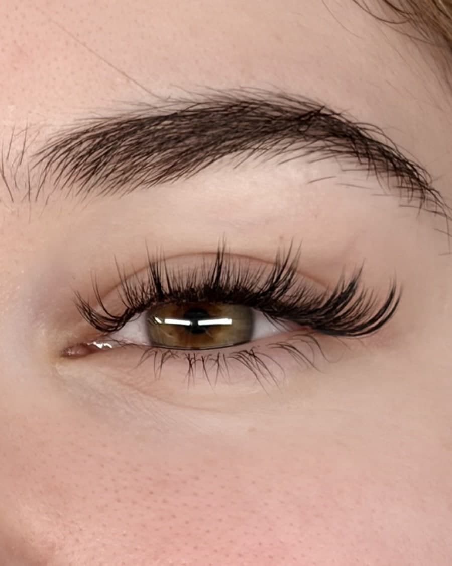 Close-up of a finished anime lash set: spiky, wispy extensions on a hazel eye
